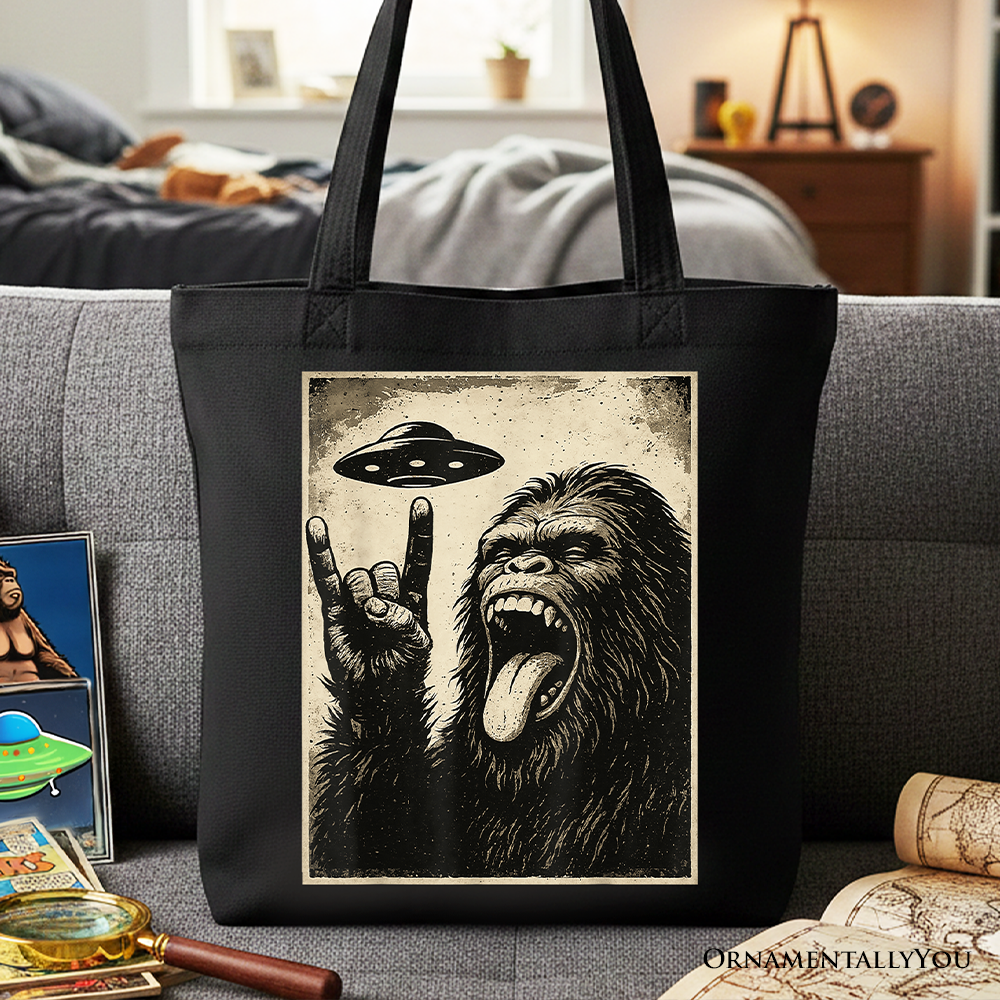 Black canvas tote bag featuring a Bigfoot UFO and Sasquatch meme design, perfect for rock and roll fans and gift shoppers.