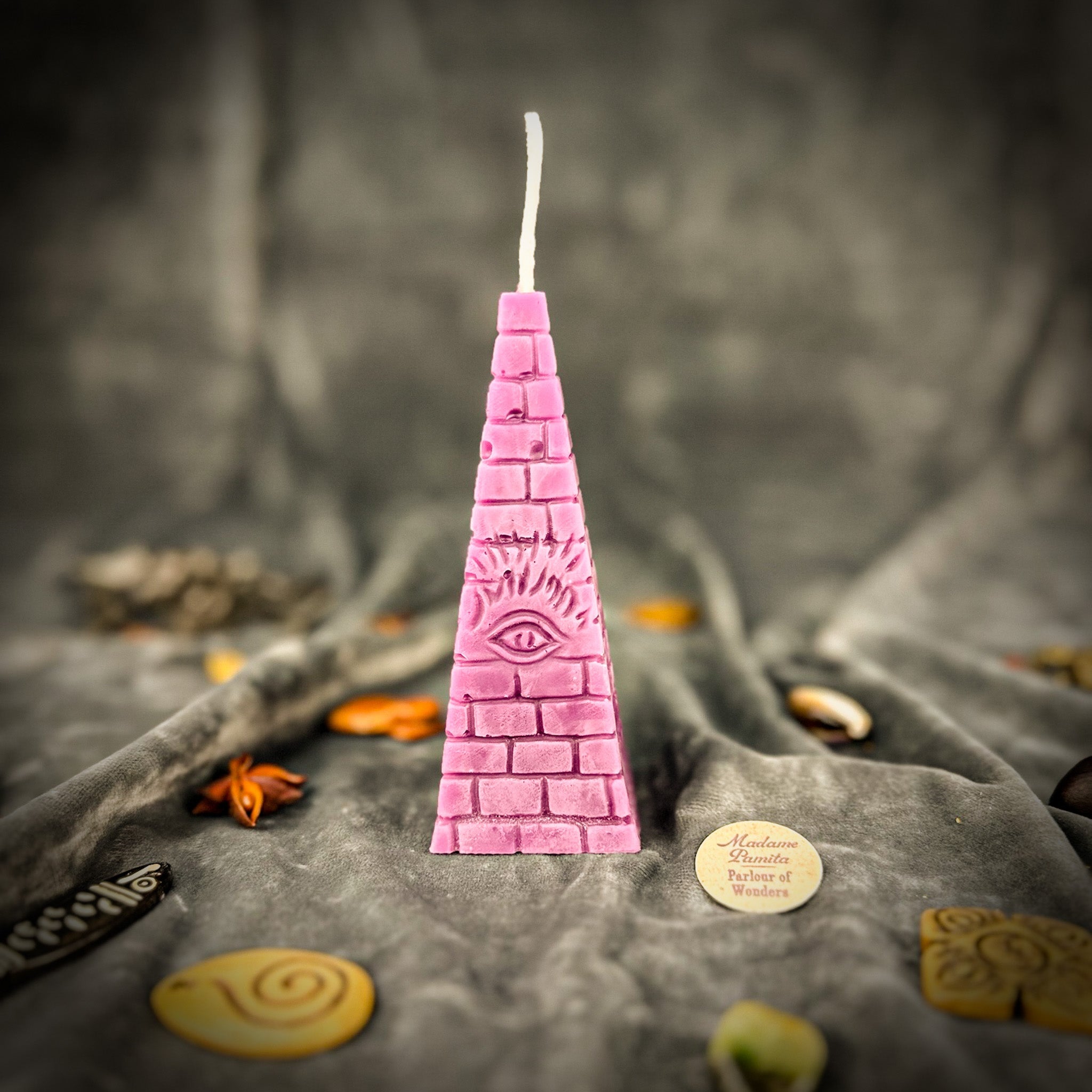 Green beeswax candle with an all-seeing eye pyramid design for abundance, prosperity, and intuition by Parlour of Wonders.