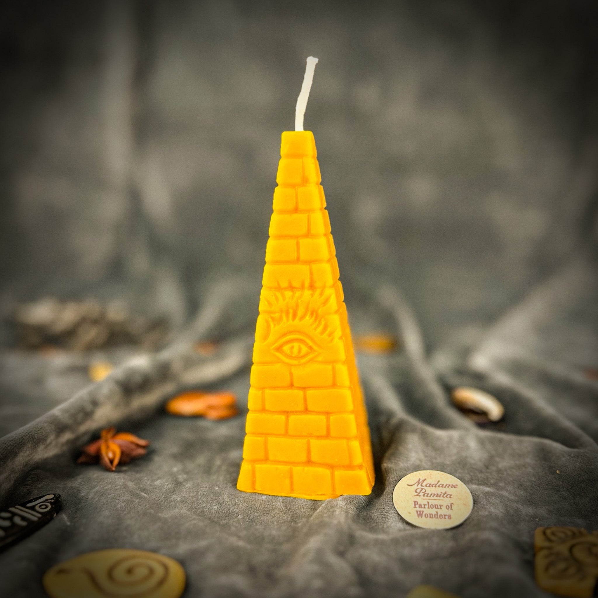 Green beeswax candle featuring an all-seeing eye pyramid design, symbolizing abundance, prosperity, and intuition.
