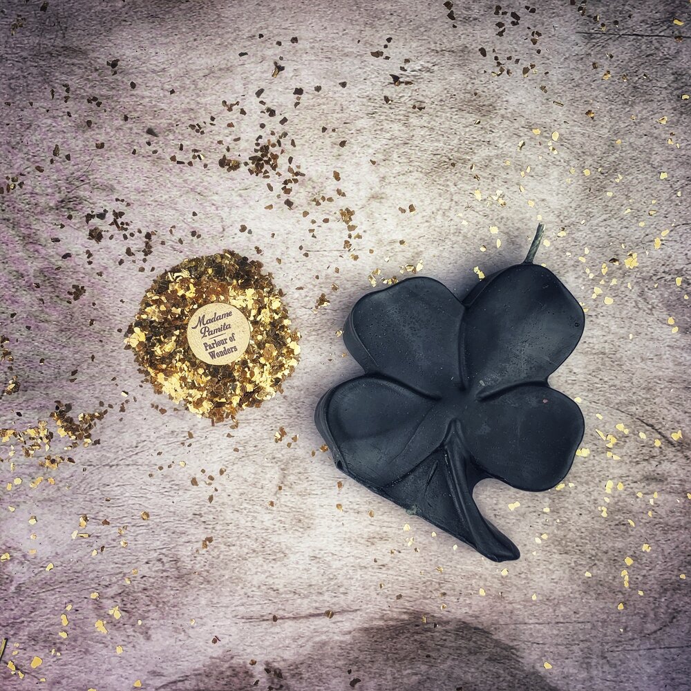 Green beeswax candle with a four-leaf clover design, representing luck and good fortune, from Parlour of Wonders.