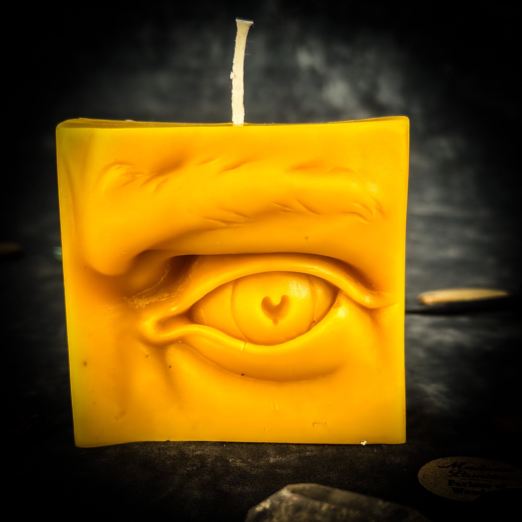 Beeswax Ex-Voto Eye Spell Candle by Parlour of Wonders for vision, clairvoyance, and being seen, with orange wax and eye design.