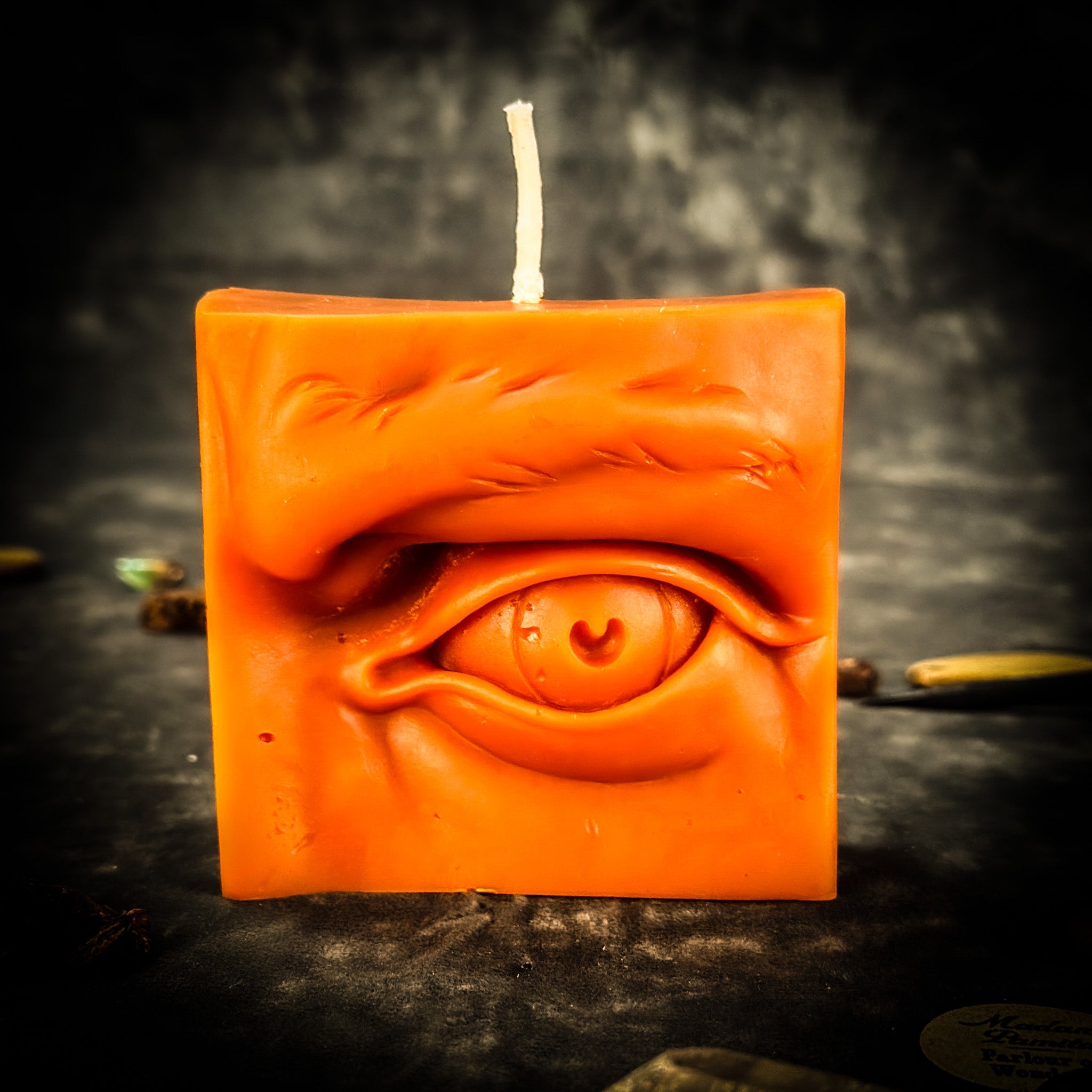 Beeswax Ex-Voto Eye Spell Candle by Parlour of Wonders for vision, clairvoyance, and being seen, with orange wax and eye symbol.
