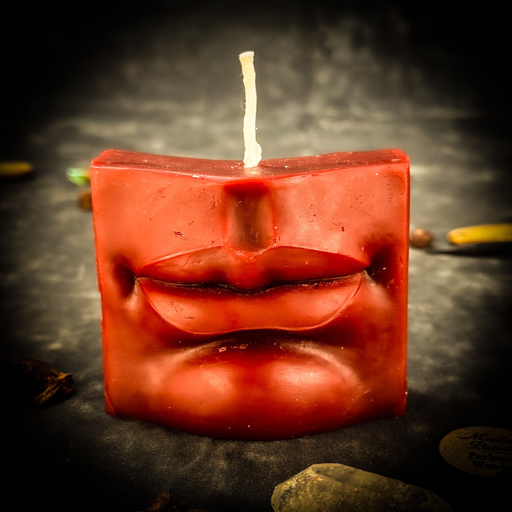 Orange beeswax candle with a mouth spell design for communication, healing, and speaking truth from Parlour of Wonders.