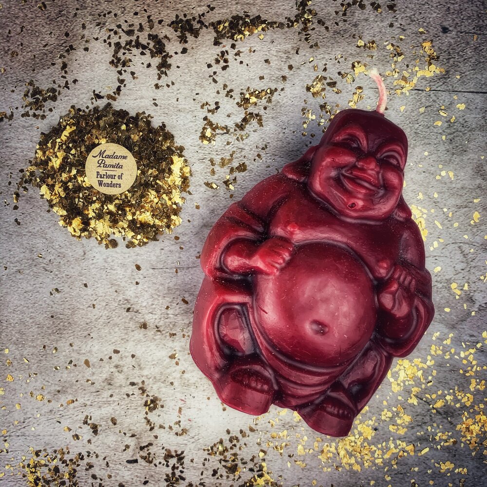 Beeswax Laughing Buddha spell candle by Parlour of Wonders for wealth, luck, and prosperity magic, orange-colored with intricate details.