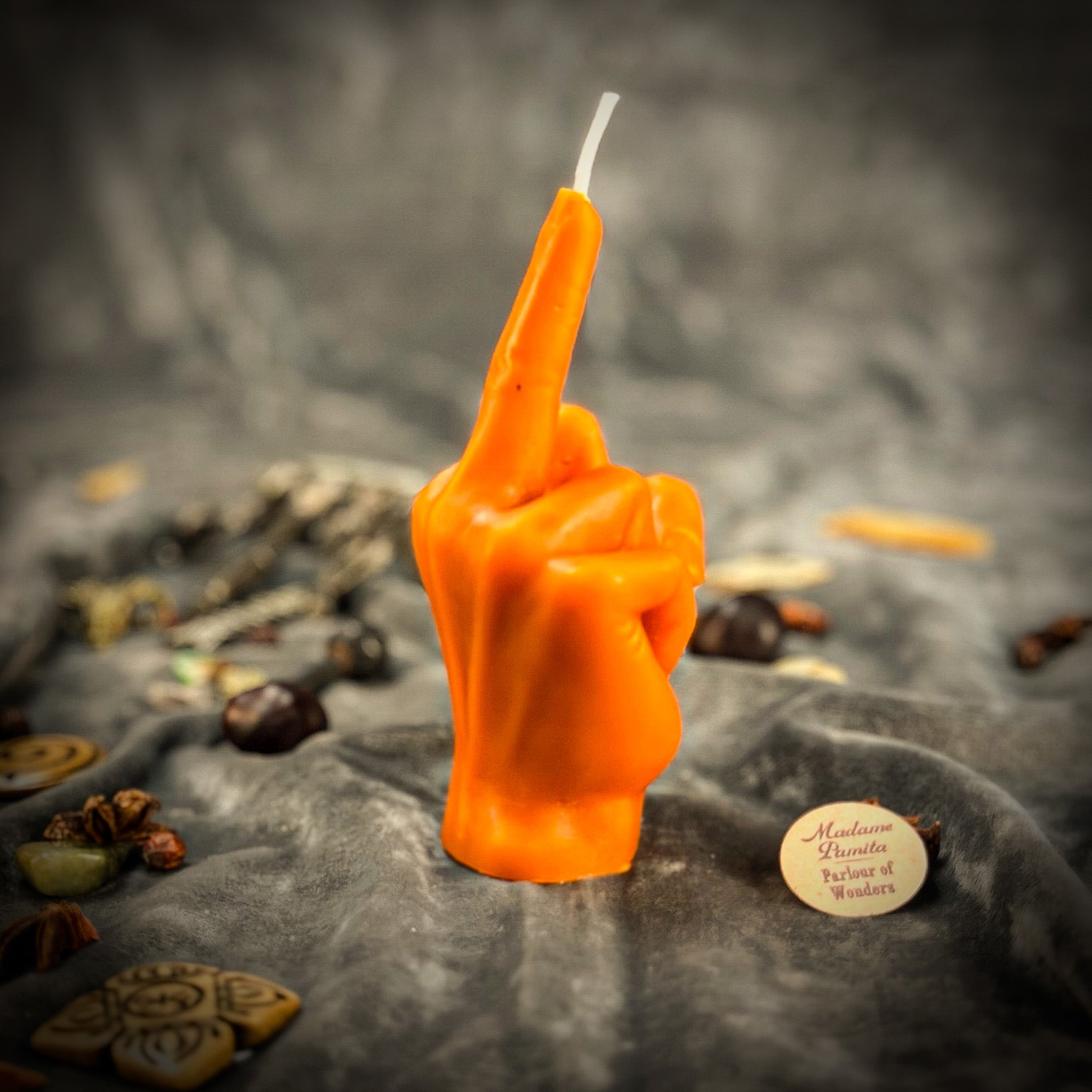 Beeswax middle finger spell candle by Parlour of Wonders with orange wax for banishing, boundaries, and empowerment.