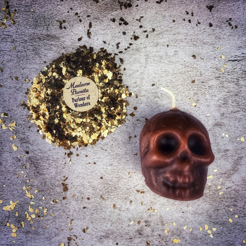 Small orange beeswax skull candle by Parlour of Wonders with intricate wax detailing, used for mind influence and ancestral wisdom magic.