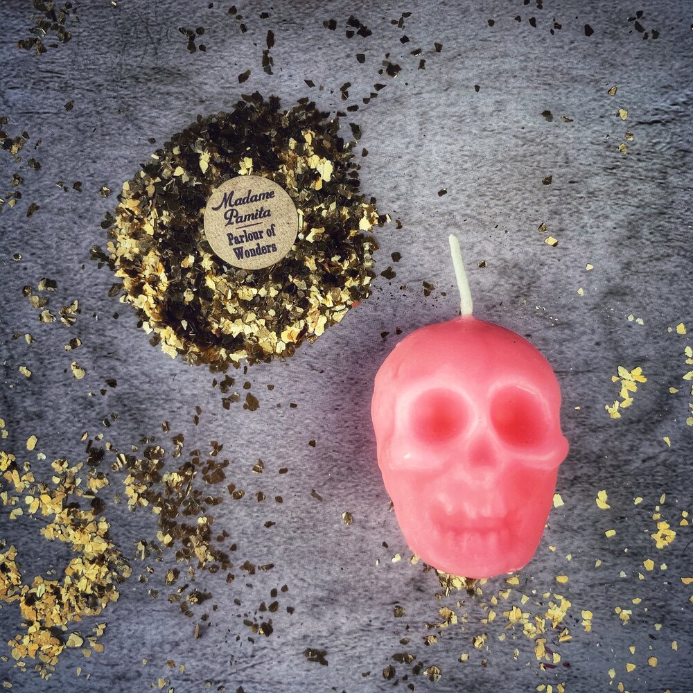 Small beeswax skull spell candle with orange coloration, designed for mind influence and ancestral wisdom magic.