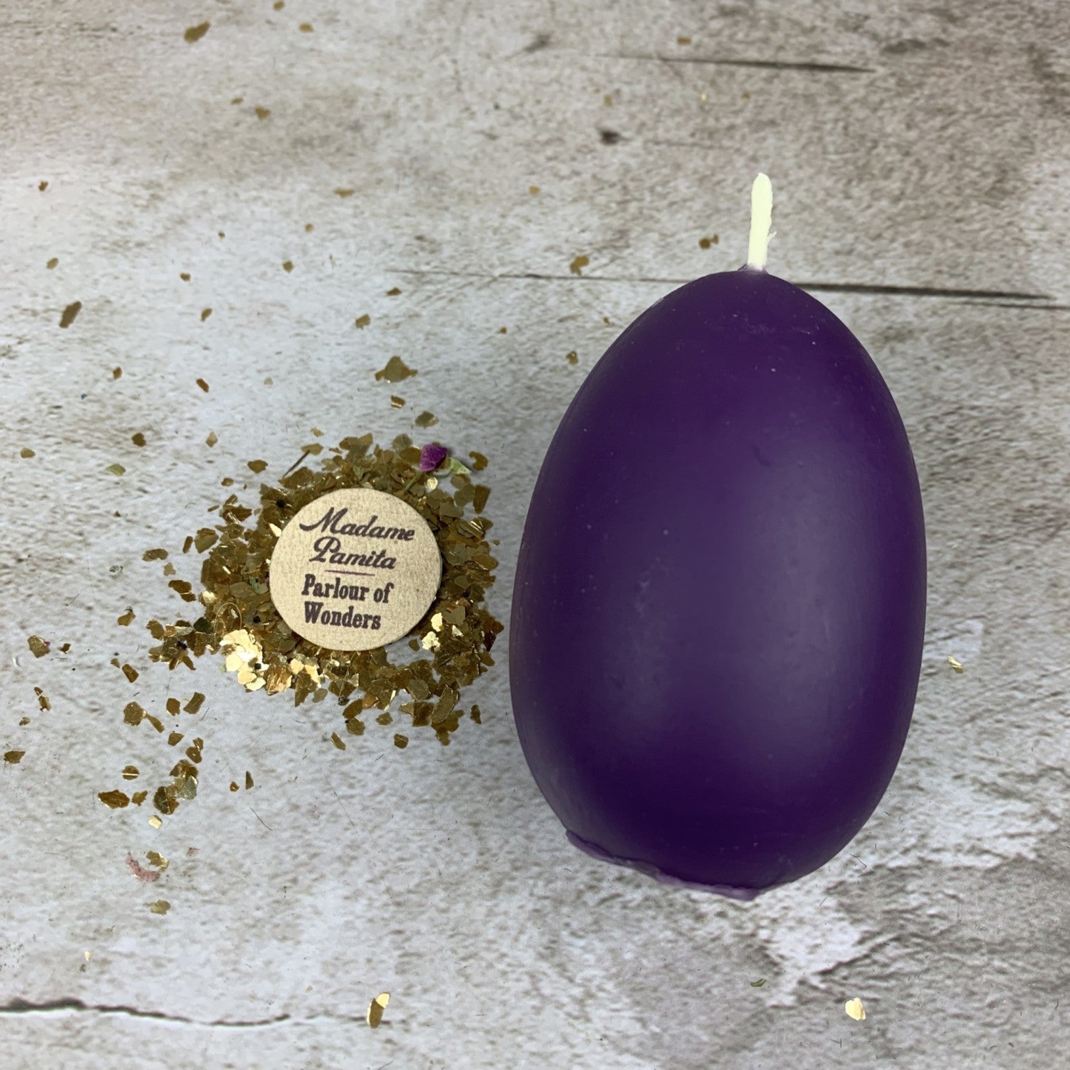 Pink beeswax egg talisman candle by Parlour of Wonders for new beginnings and fertility magic, with intricate design and natural wax texture.