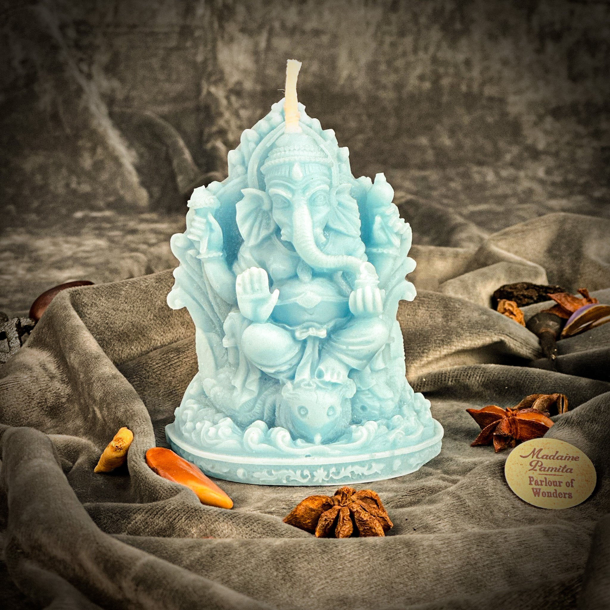 Red beeswax Ganesha spell candle from Parlour of Wonders for obstacle removal and success magic, featuring intricate Ganesha design.