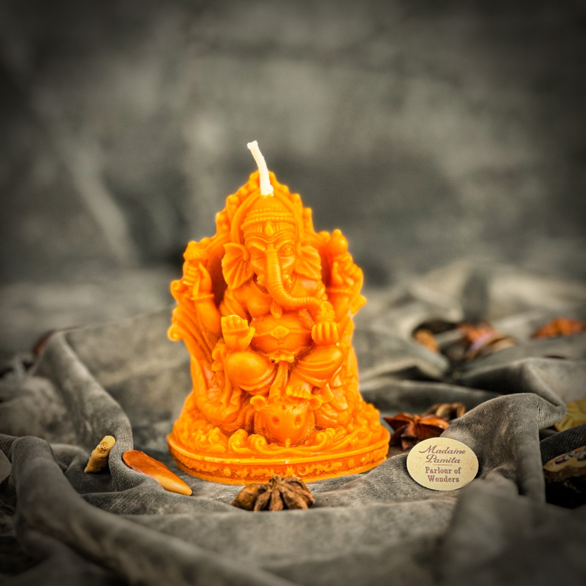 Red beeswax Ganesha spell candle from Parlour of Wonders with intricate carvings, used for obstacle removal and success magic.