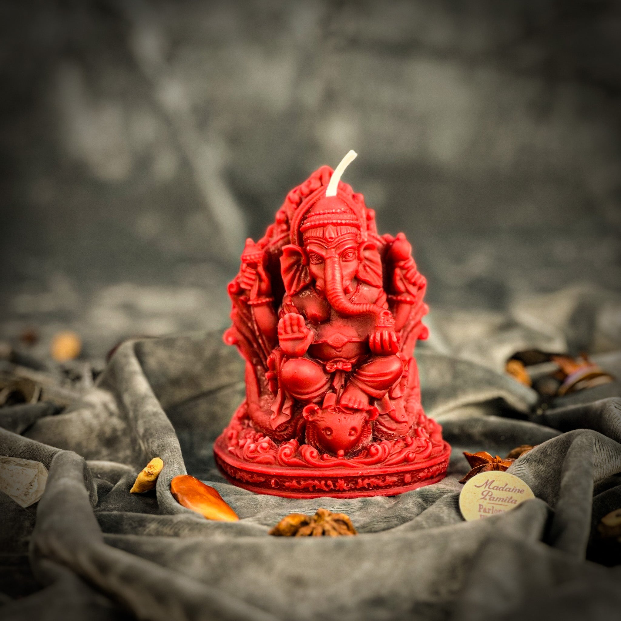 Red beeswax Ganesha spell candle by Parlour of Wonders for obstacle removal and success magic, featuring detailed Ganesha figure.