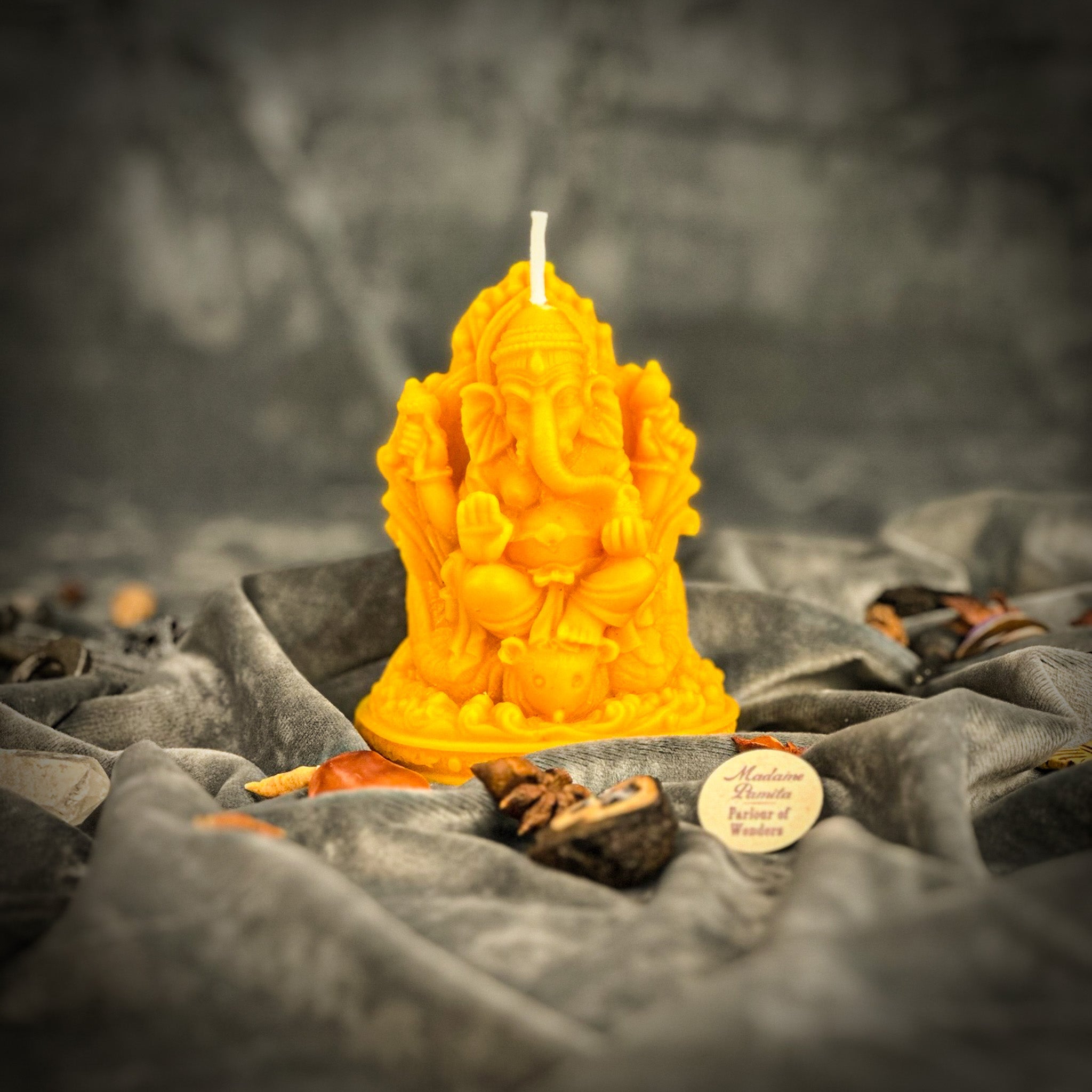 Red beeswax Ganesha spell candle from Parlour of Wonders with intricate carvings, used for obstacle removal and success magic.