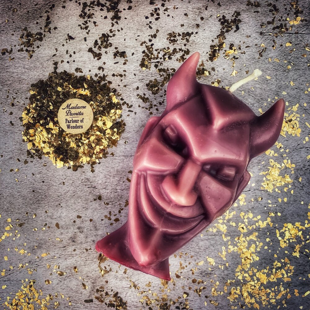 Red beeswax candle from Parlour of Wonders for spellwork, featuring intricate devil run design for banishing evil and invoking trickster magic.