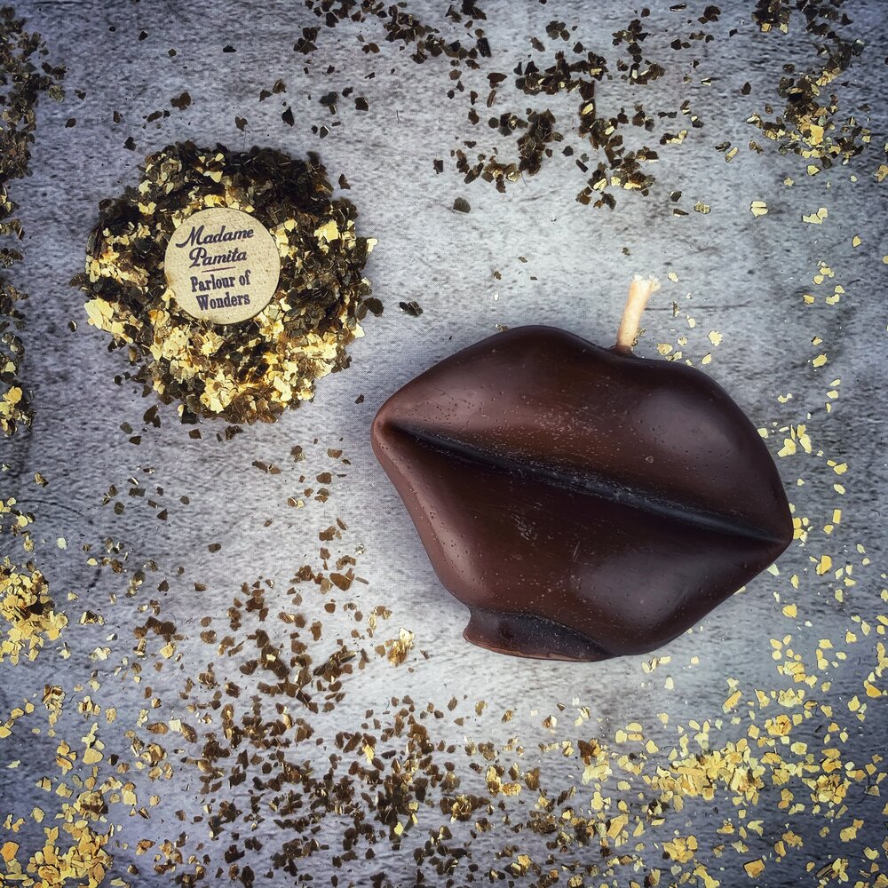 Red beeswax candle shaped like lips with "Talk to Me" inscription, used for communication and passion magic by Parlour of Wonders.