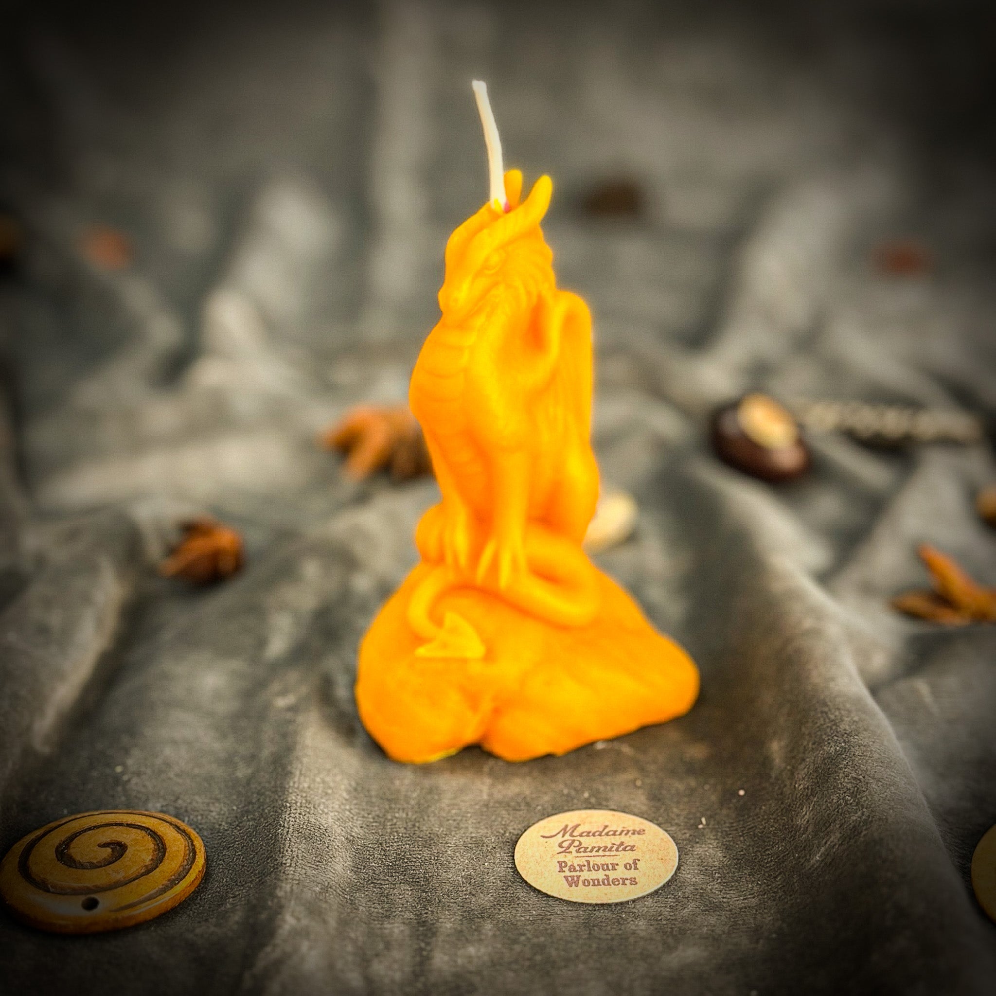 Yellow beeswax candle featuring a carved dragon design for protection, guardian magic, and defensive power.