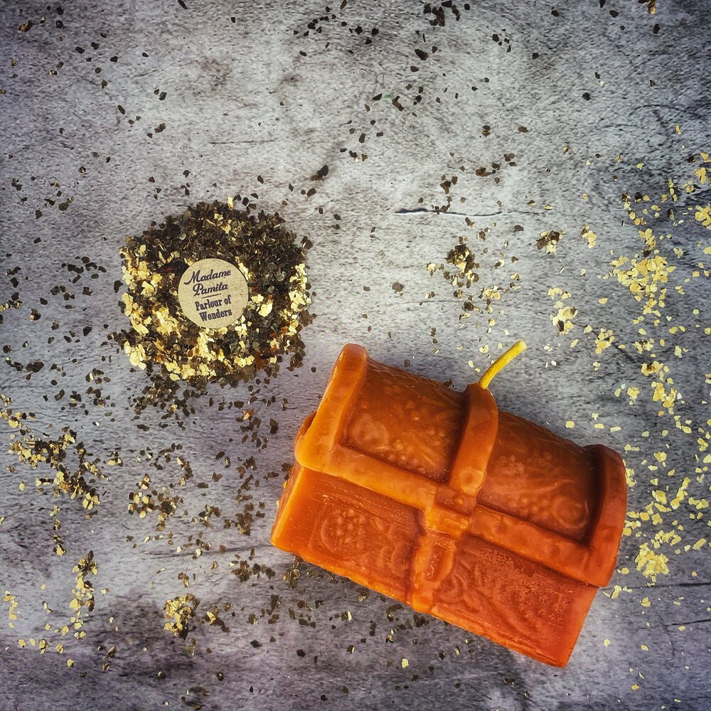 Yellow beeswax candle in the shape of a treasure chest, used for spells to unlock blessings and attract abundance.
