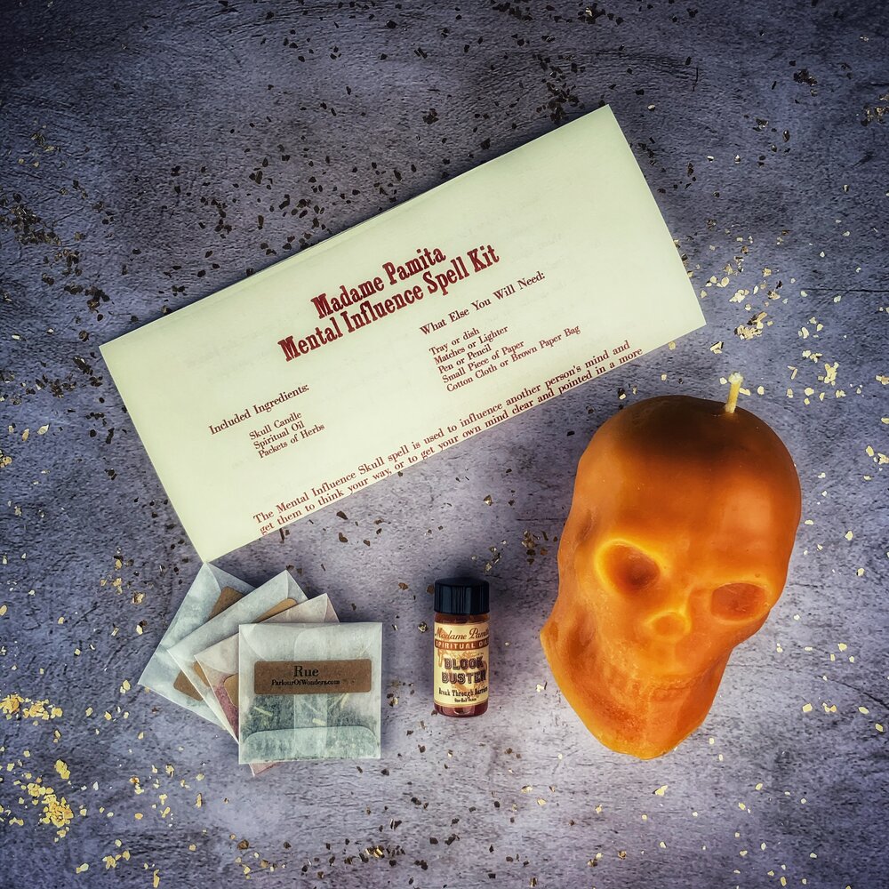 Orange Skull Candle Spell Kit for mental influence and clarity by Parlour of Wonders, featuring a skull-shaped candle and ritual accessories.