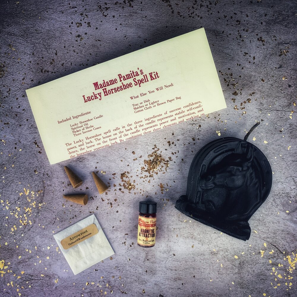 Red Lucky Horseshoe Candle Spell Kit by Parlour of Wonders featuring candles, horseshoe charm, and magical tools for luck and power spells.