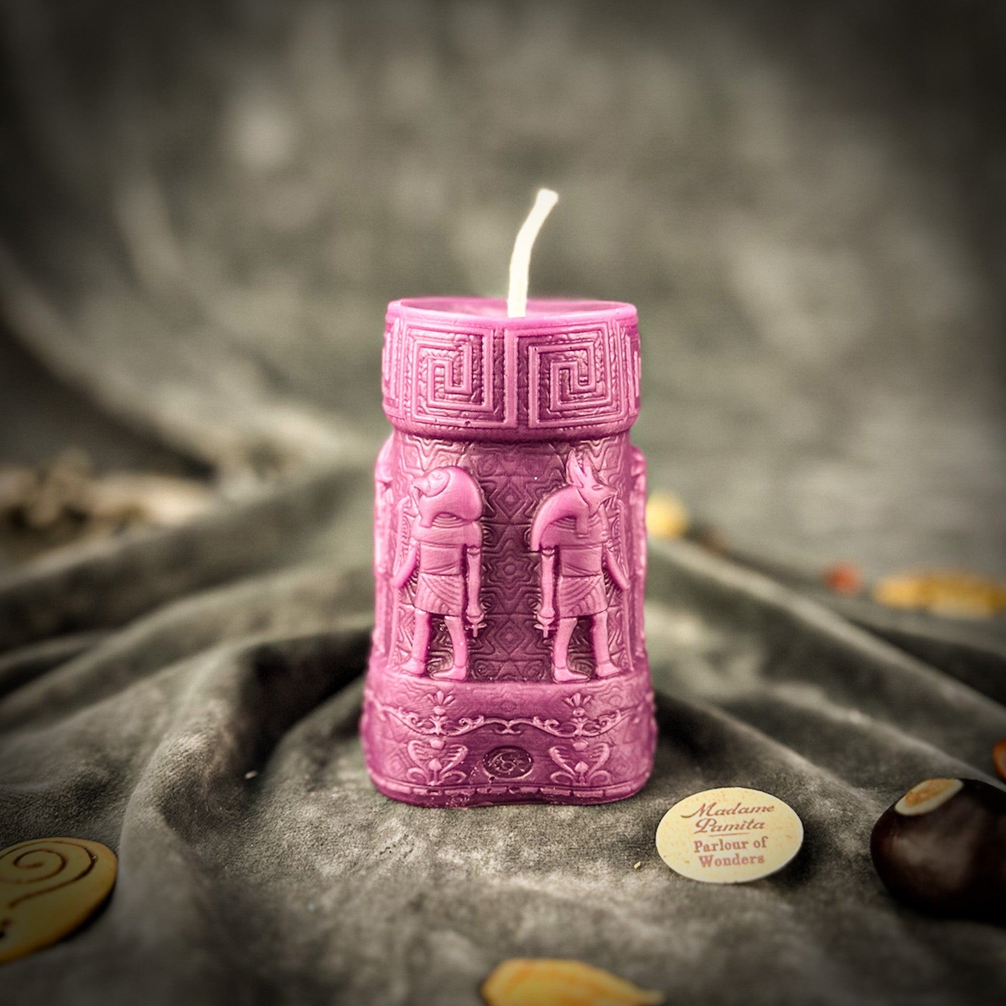 An Egyptian Candle Spell Kit featuring yellow pillar candles with Anubis and Horus imagery for protection and divine guidance.