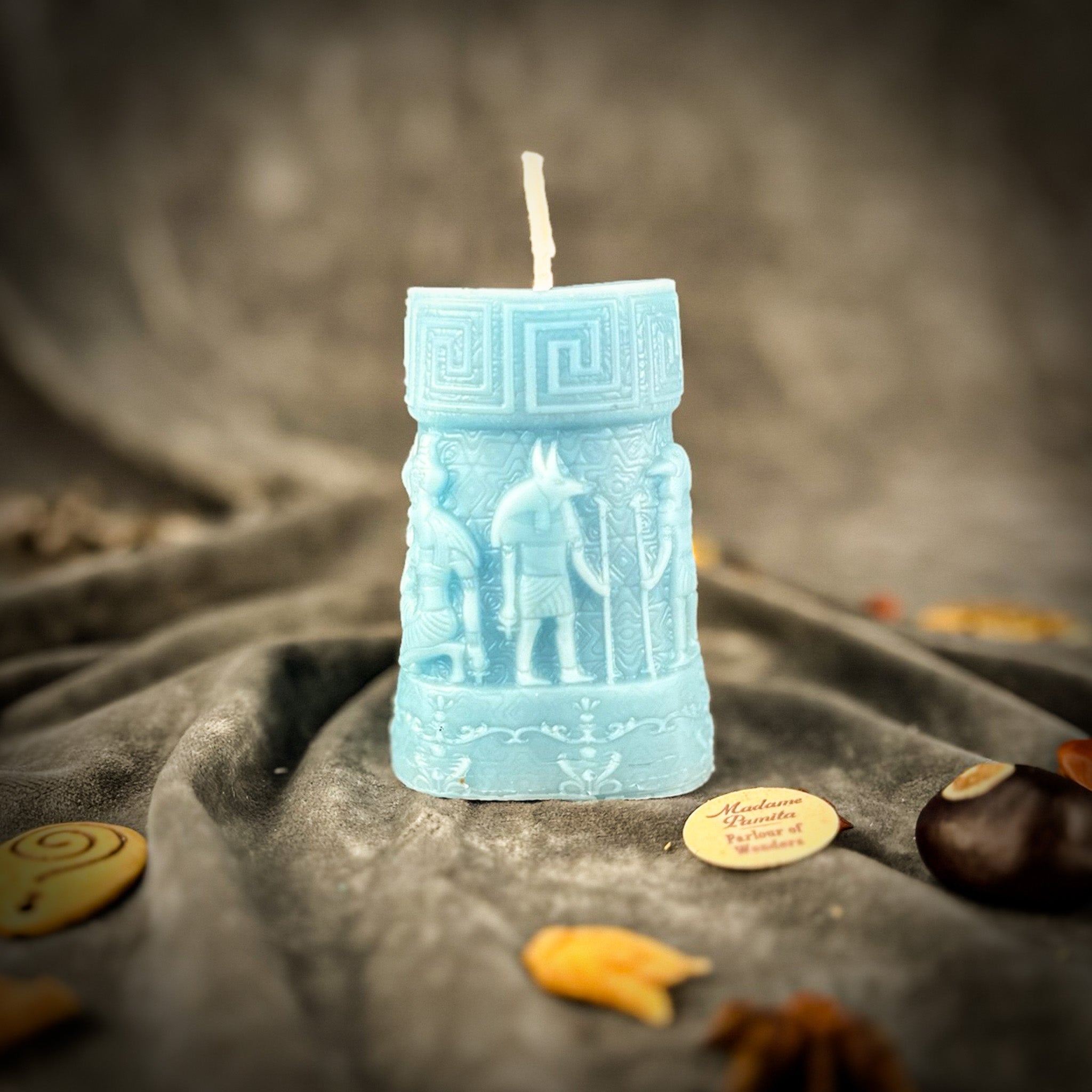Egyptian pillar candle spell kit featuring Anubis and Horus for protection and divine guidance, with yellow candles and ritual tools.