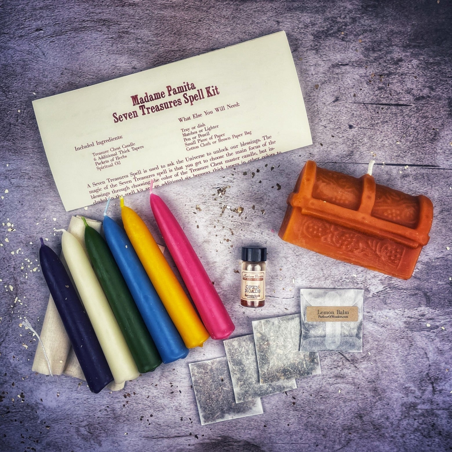 Parlour of Wonders Seven Treasures Candle Spell Kit with yellow candles for blessings and abundance, displayed on a wooden surface.