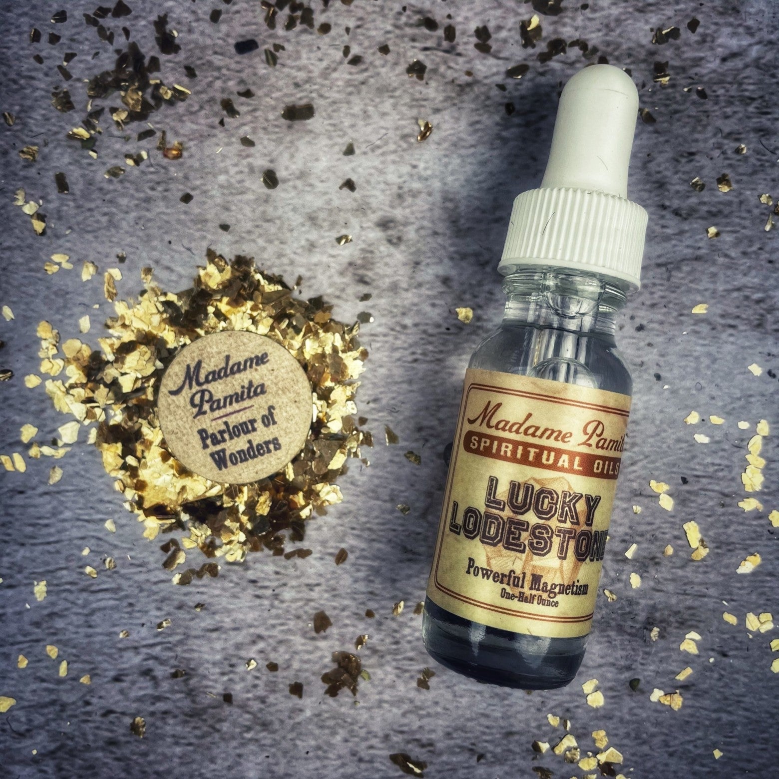 Lucky Lodestone Oil by Madame Pamita for attraction and luck, shown in a small glass bottle with a black cap.