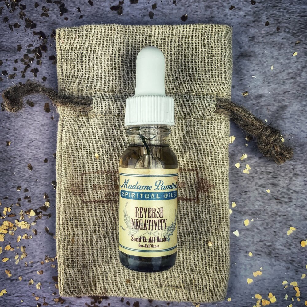 Bottle of Reverse Negativity Oil by Madame Pamita from Parlour of Wonders, with dark glass container and label visible.