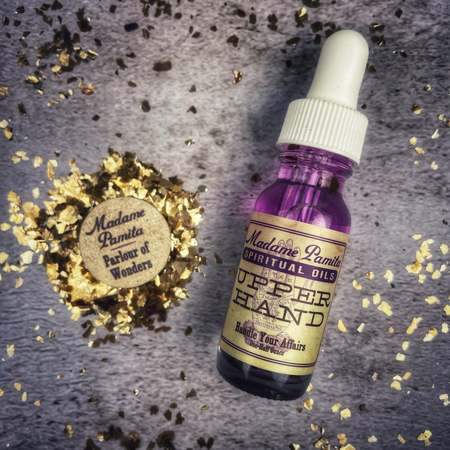 Upper Hand Oil by Madame Pamita from Parlour of Wonders, featuring a small glass bottle with herbal-infused hand oil.