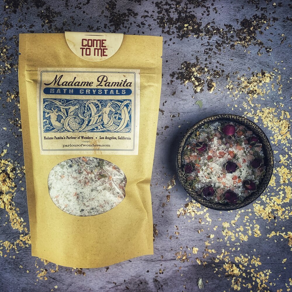 Small jar of Parlour of Wonders Come to Me Bath Crystals with pink and white crystals in a clear container.