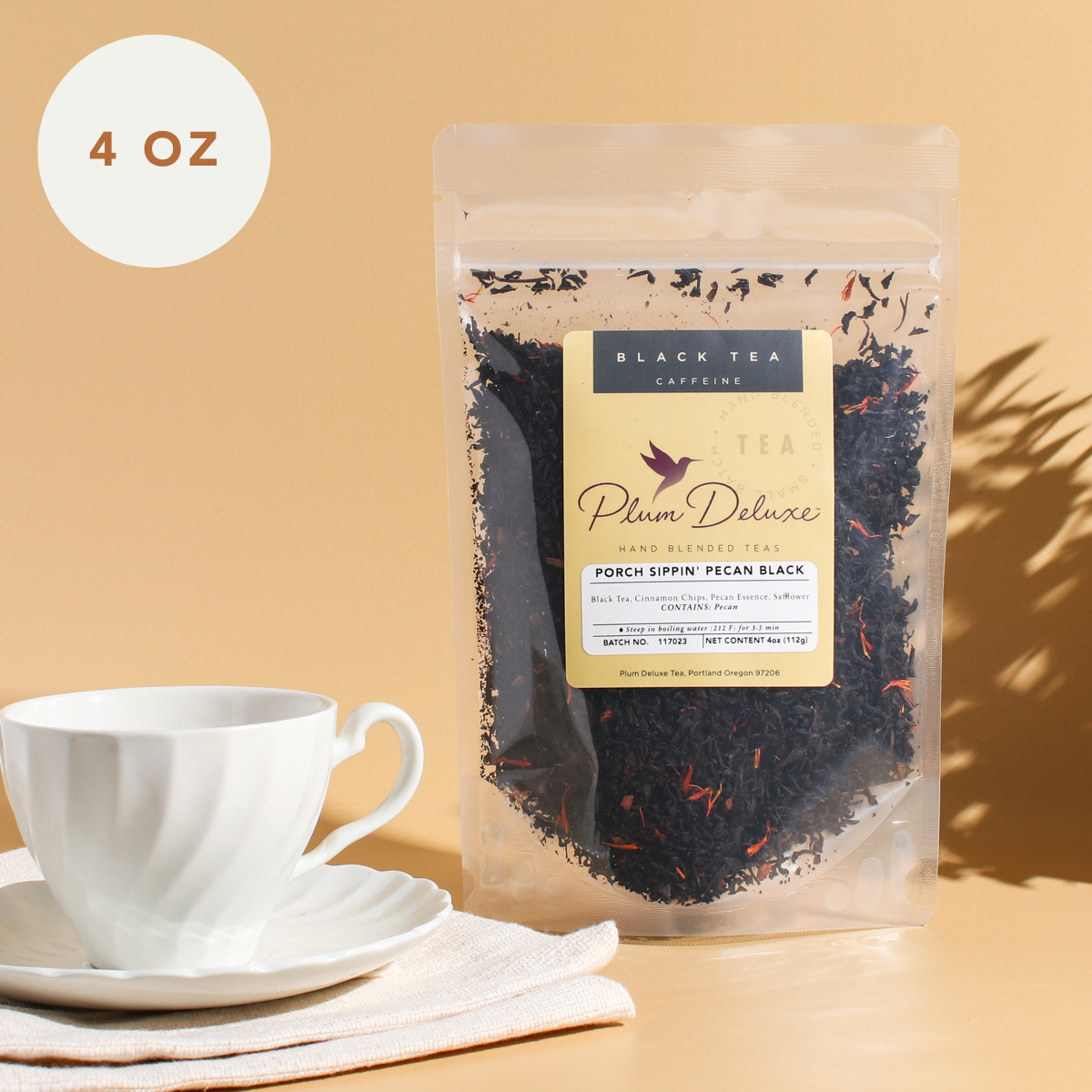 Plum Deluxe Porch Sippin' Pecan Black Tea in a clear tea container, showing rich dark tea leaves with pecan flavor accents.
