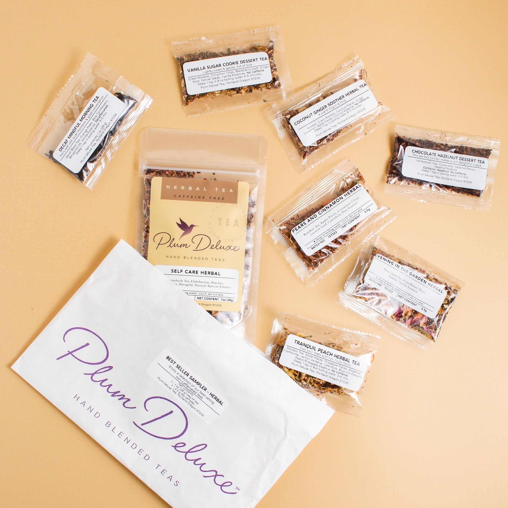 Assorted Plum Deluxe Tea Best Sellers Sampler Set featuring various caffeinated tea blends in colorful packaging.