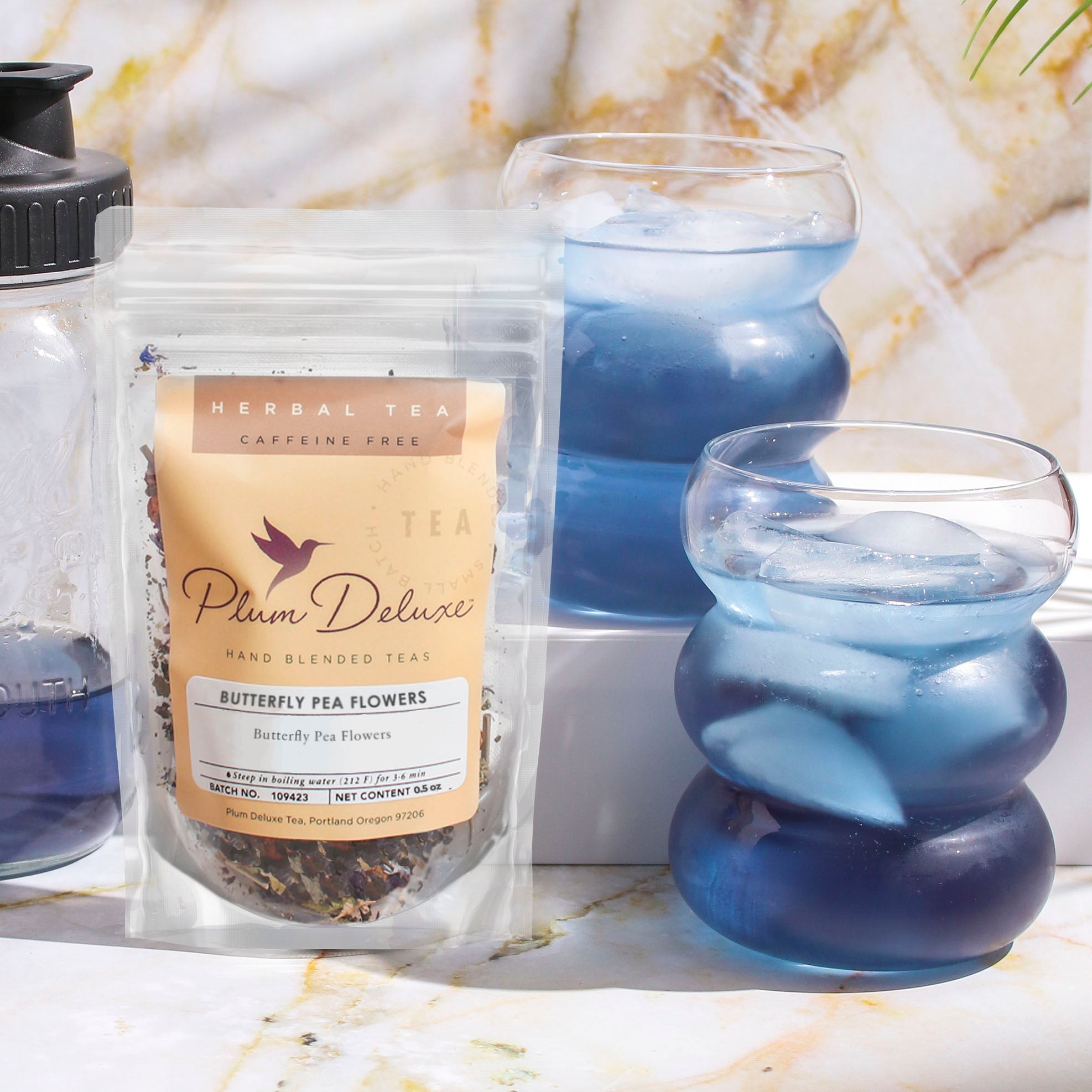 Dried butterfly pea flowers from Plum Deluxe Tea, vibrant blue-purple petals used for herbal teas and infusions.