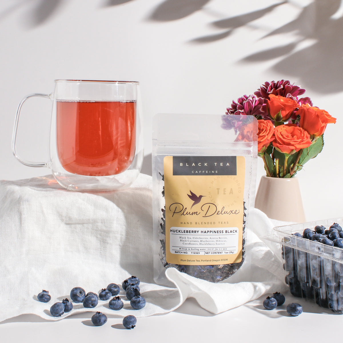 Cup of Plum Deluxe Huckleberry Happiness Black Tea in a teacup, showcasing the tea's rich color and fresh fruit infusion.