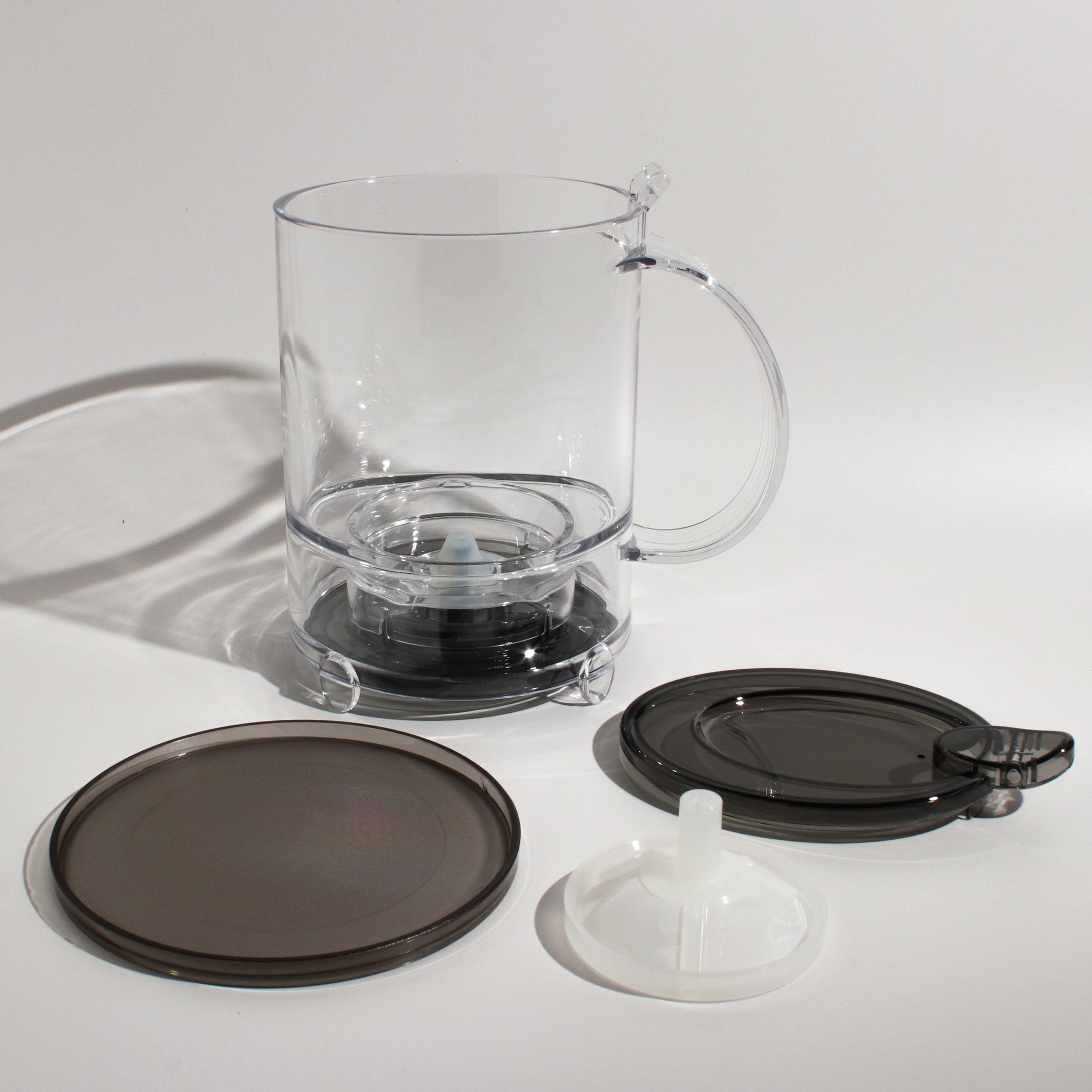 Plum Deluxe Tea Perfect Tea Maker with glass brewing chamber and stainless steel lid for easy tea preparation.