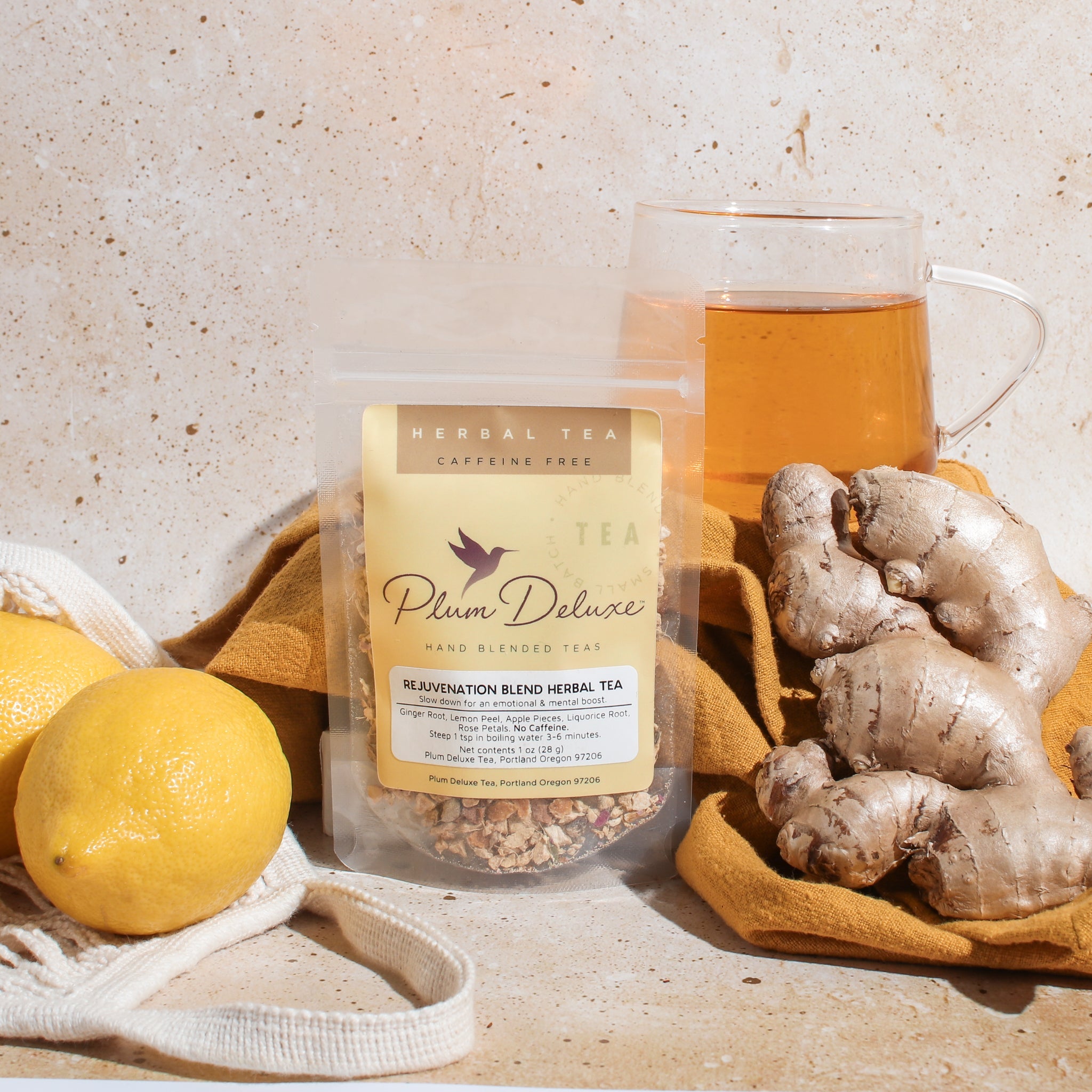 Herbal tea blend with ginger and lemon in a glass cup, featuring fresh lemon slices and ginger root for rejuvenation.