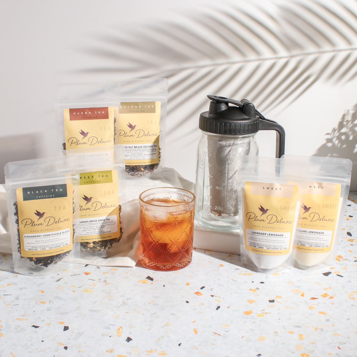 Plum Deluxe Tea Ultimate Iced Tea Bundle with tea, pitcher, and lemon slices for refreshing cold beverages.