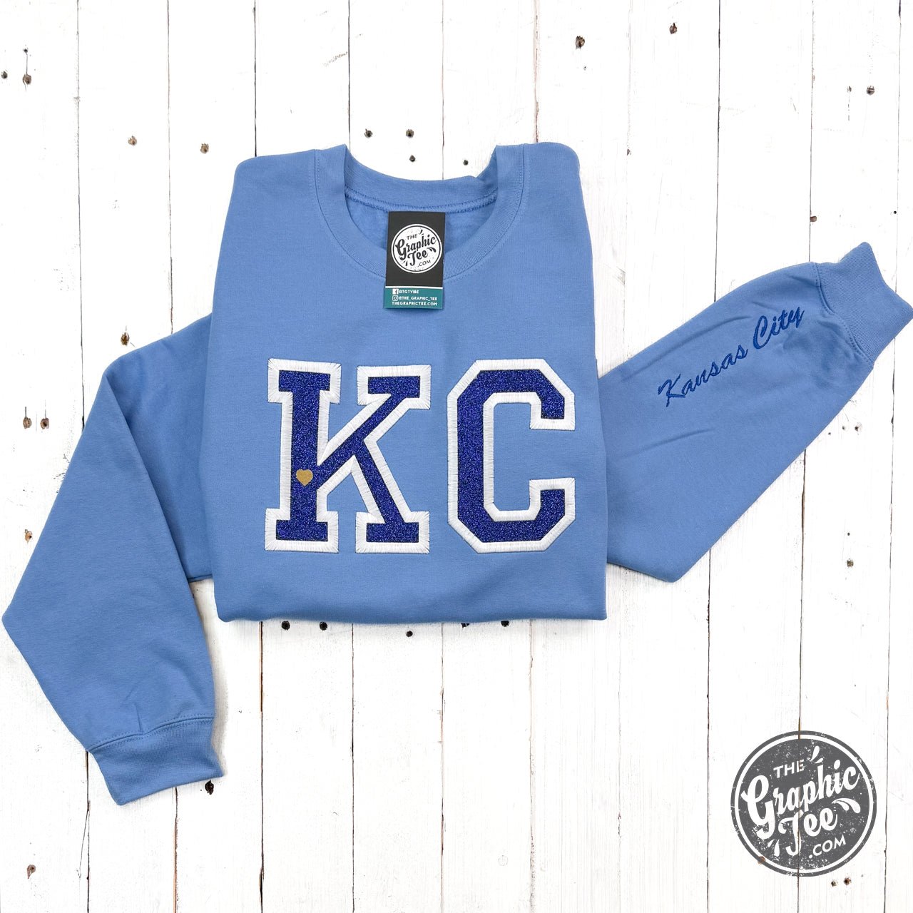 Powder blue KC glitter applique crewneck sweatshirt from The Graphic Tee featuring a casual, stylish design with glitter accents.