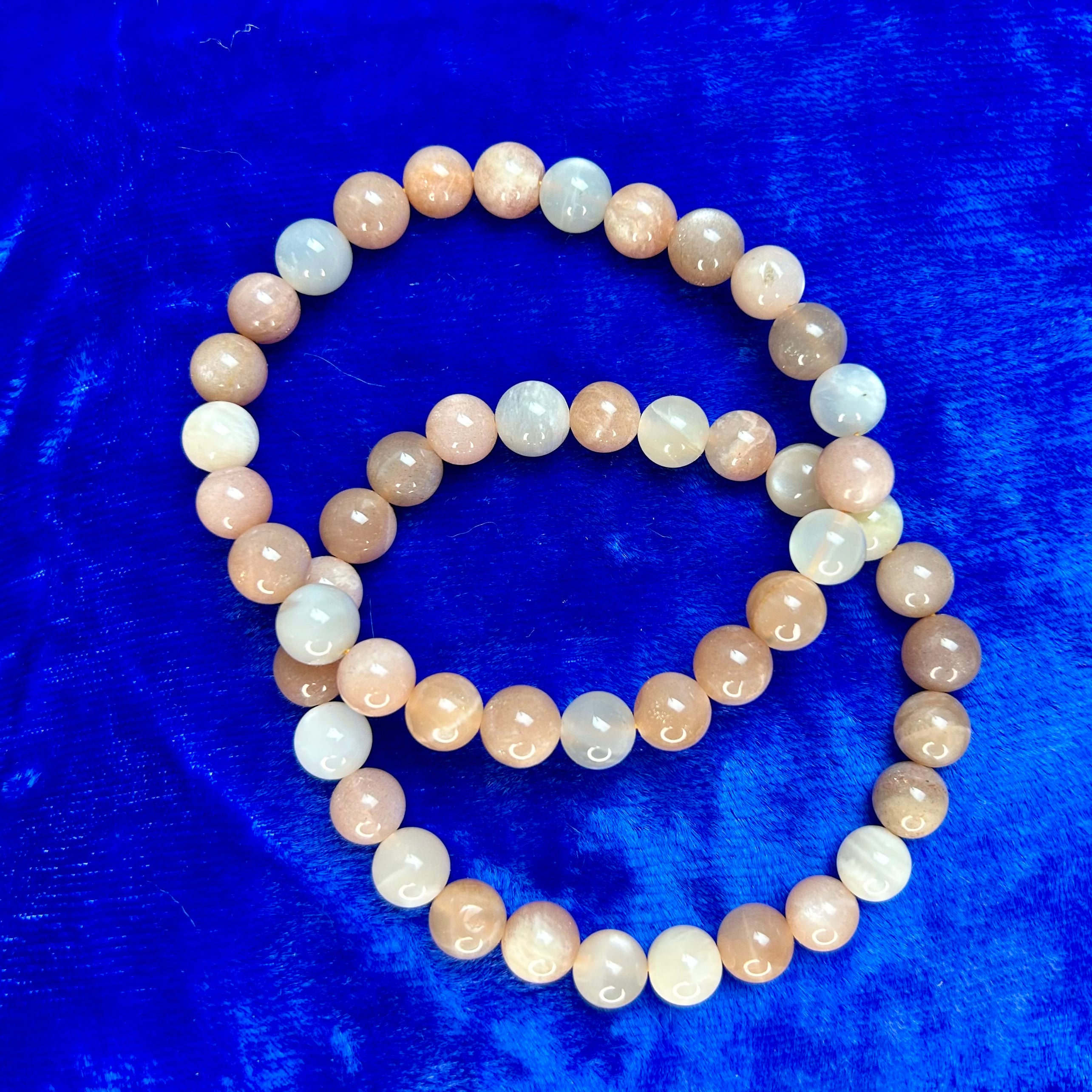 Mixed moonstone bracelet with 8 mm beads from Practical Magic Store, featuring smooth, iridescent stones on a flexible bracelet.