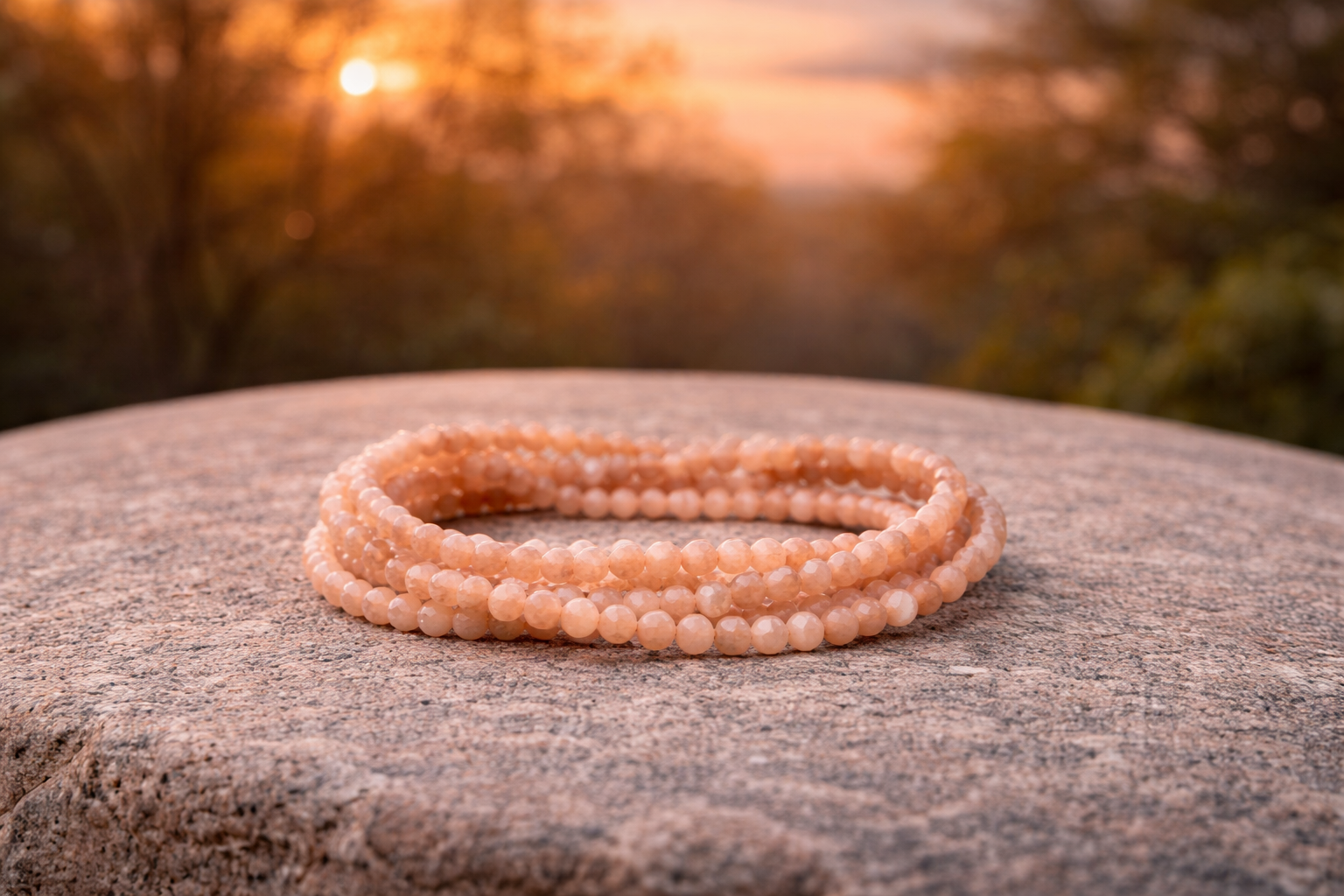 4mm faceted natural peach moonstone crystal energy bracelet showing polished stones with subtle color variations and a clasp.