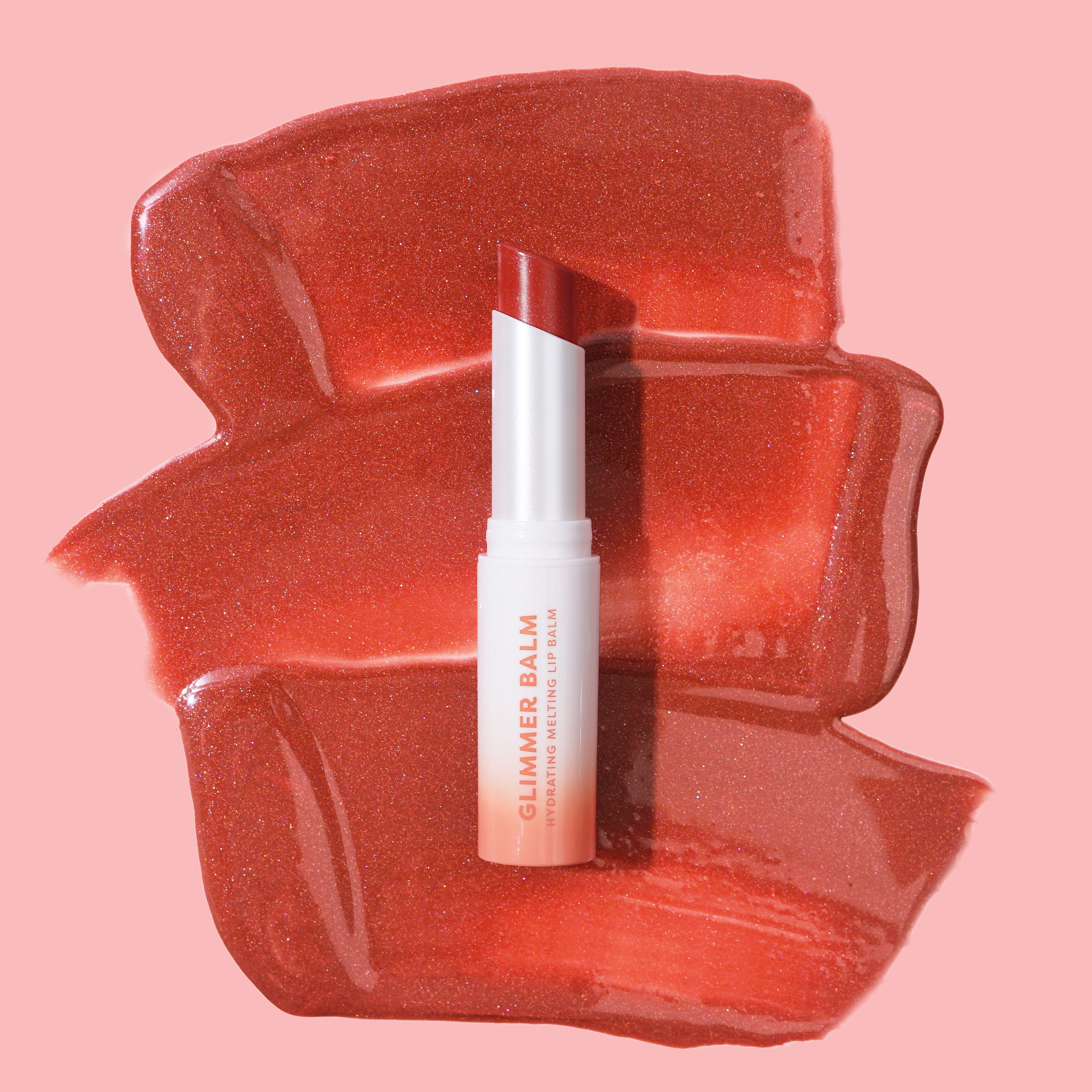 Profusion Cosmetics Glimmer Balm hydrating melting lip balm in coral shade, moisturizing lips with a shimmering finish.