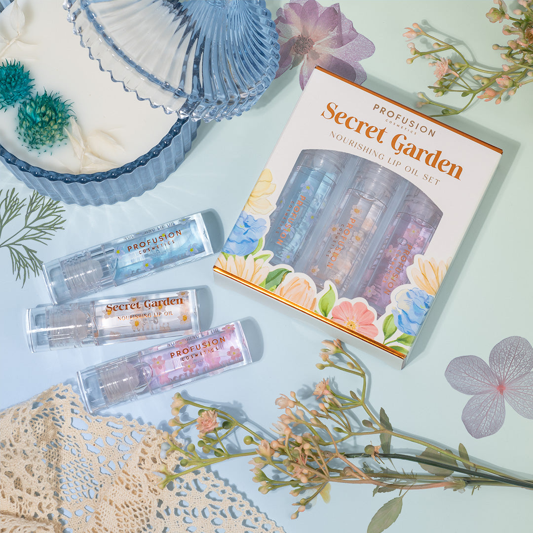 Profusion Cosmetics Petal Perfect Secret Garden Nourishing Lip Oil Set with floral packaging and glossy lip oils displayed.