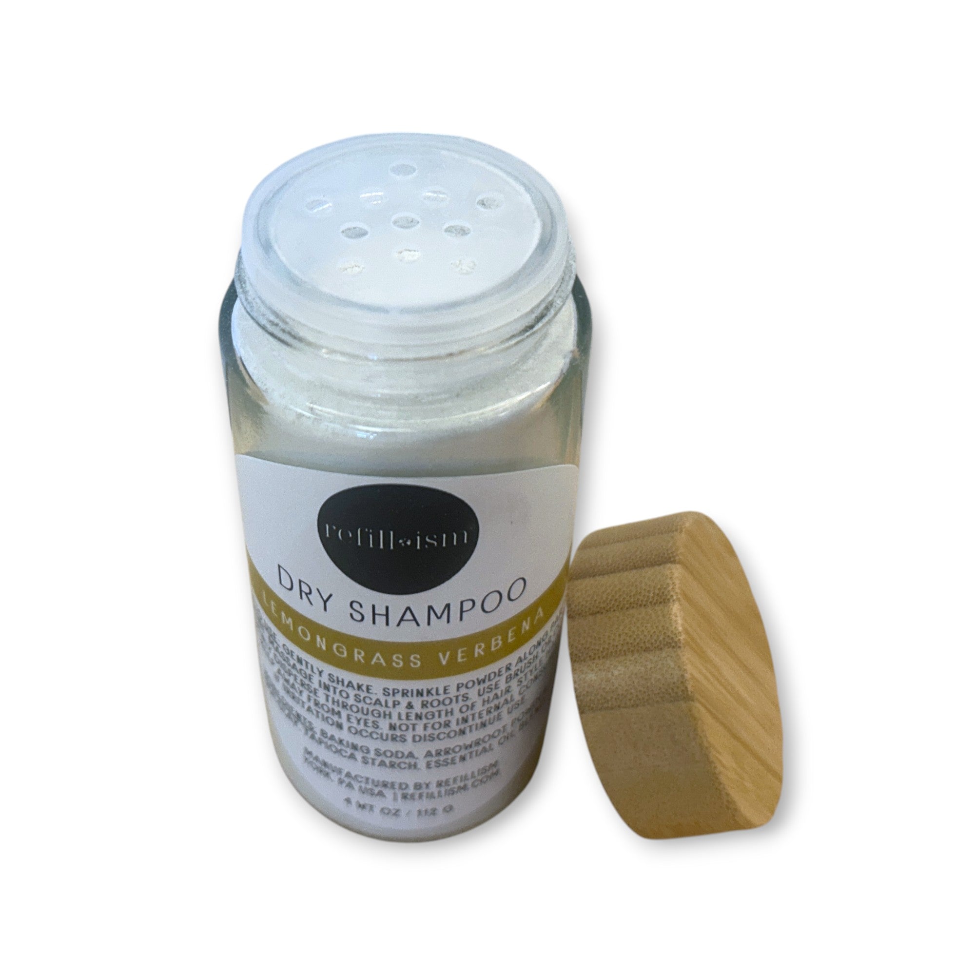 Refillism dry shampoo in lemongrass and verbena scent, in a glass shaker bottle, for fresh and clean hair care.