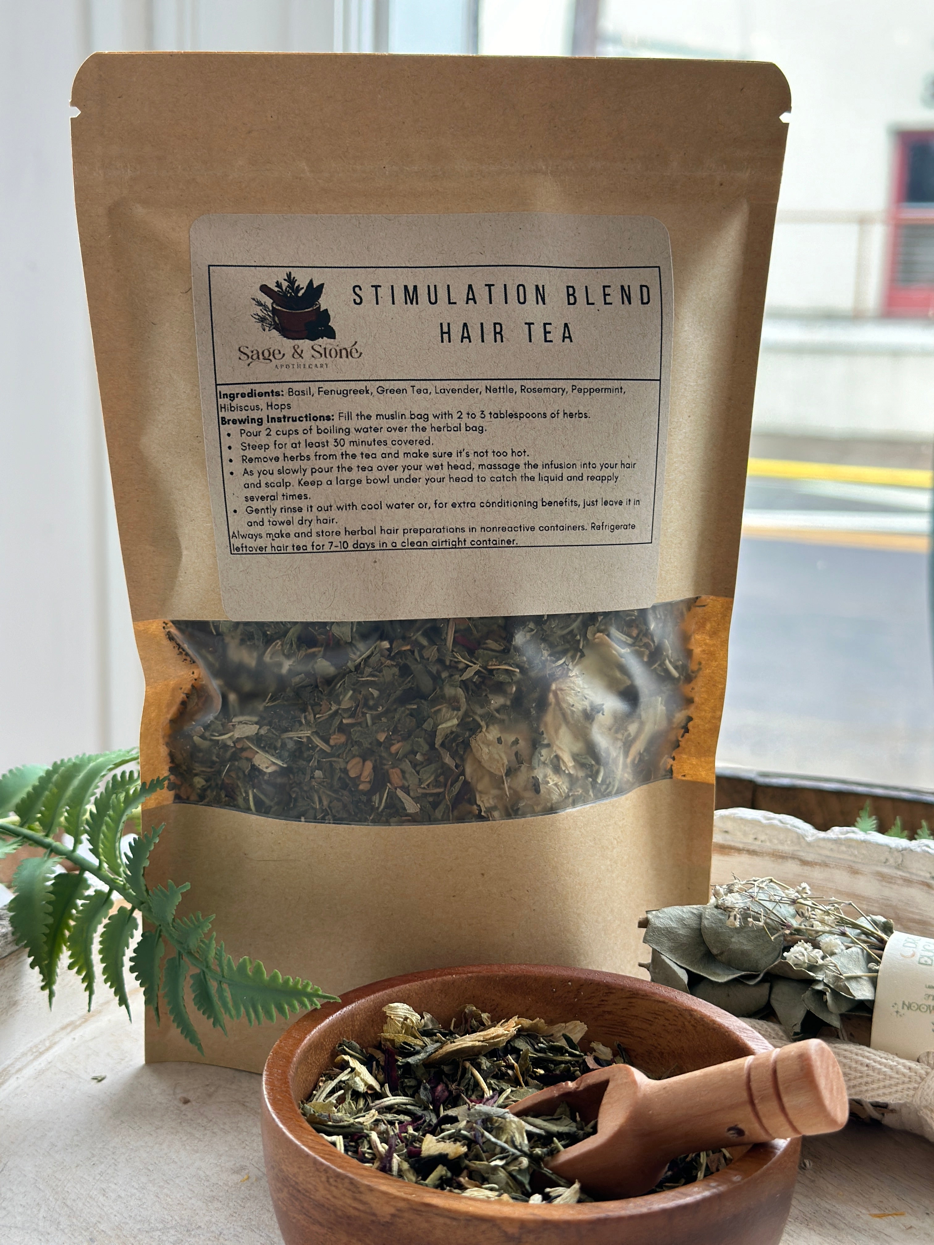 Herbal hair stimulation tea blend from Sage & Stone Apothecary in a glass jar, with dried herbs and tea leaves visible.