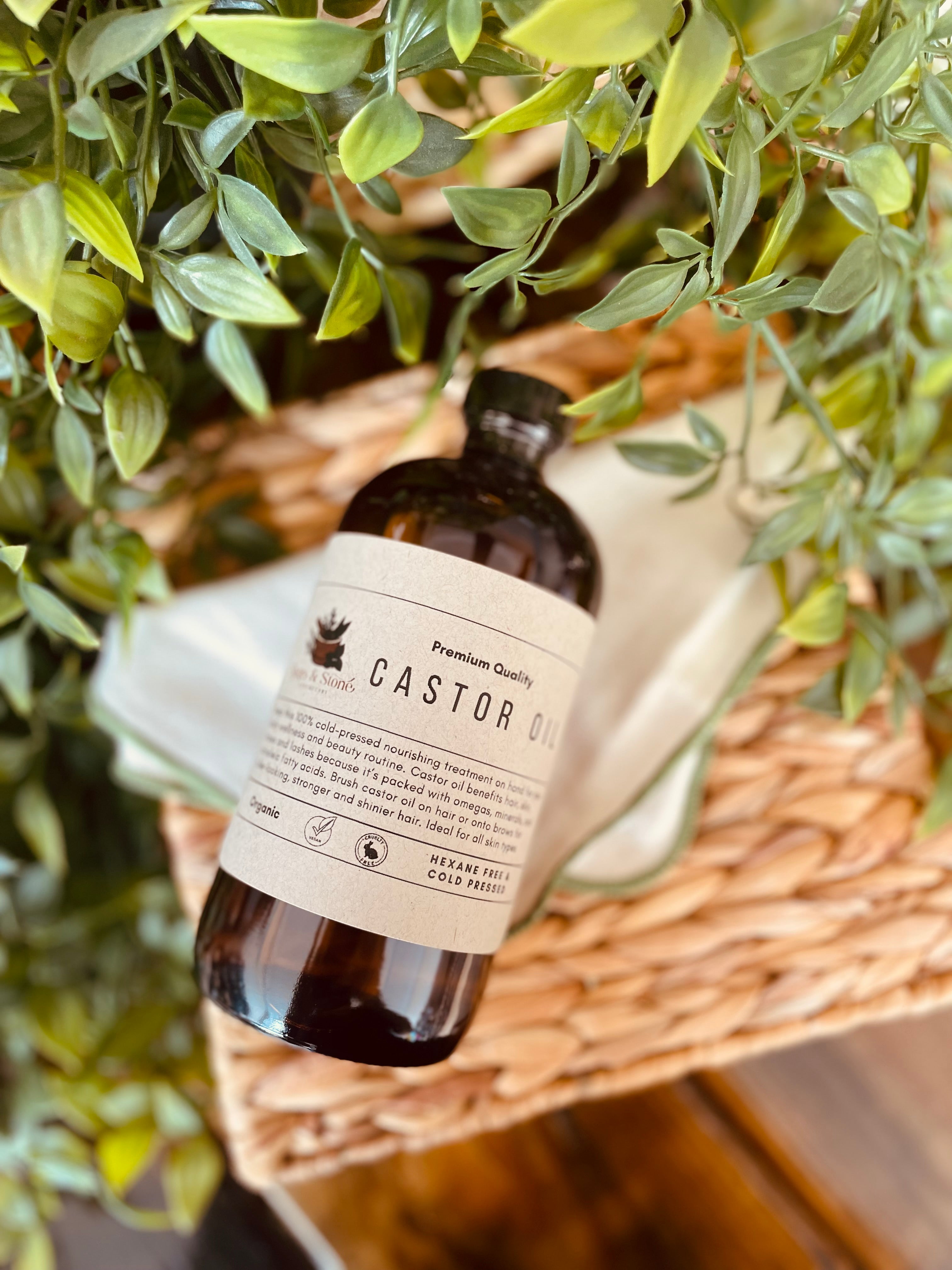 Organic cold pressed castor oil bottle from Sage & Stone Apothecary, showcasing clear glass container with golden oil inside.