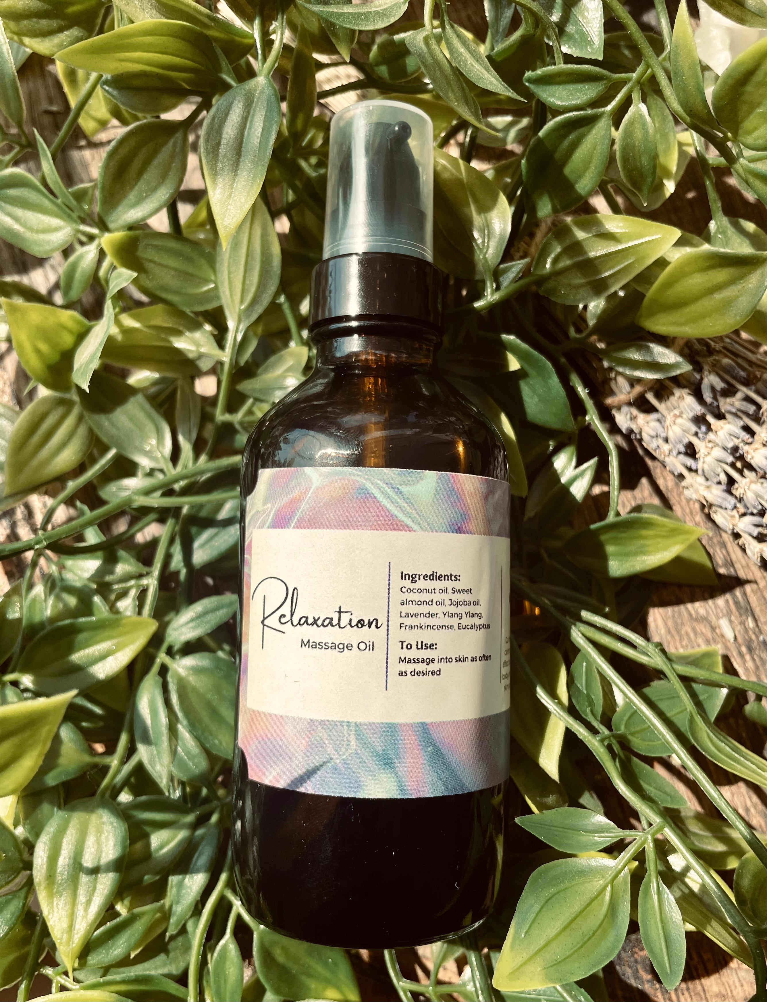 Bottle of Sage & Stone Apothecary massage oil with a pump dispenser, featuring a clear glass container and natural oil inside.