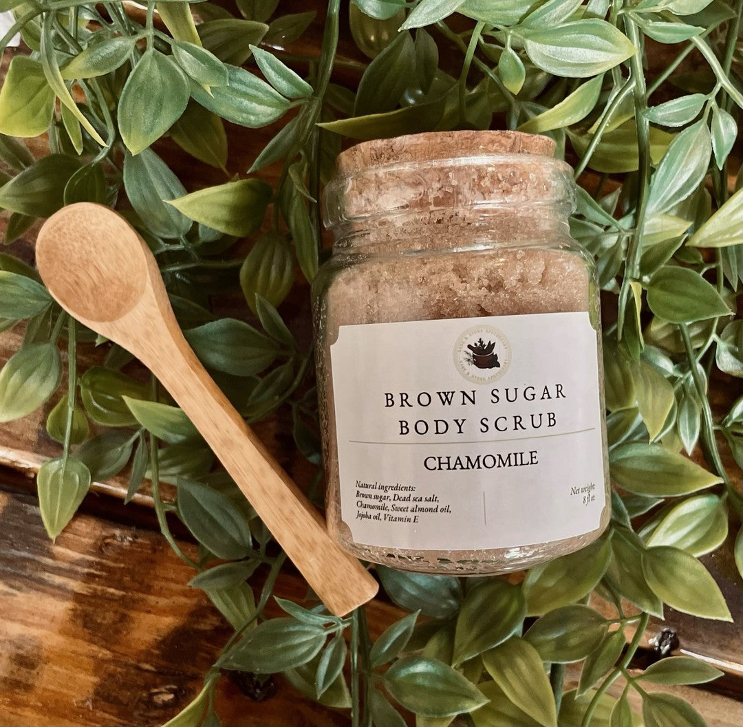 Brown Sugar Chamomile Scrub by Sage & Stone Apothecary, creamy texture with brown sugar and chamomile herbs in a jar