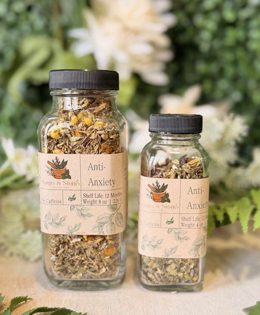 Sage & Stone Apothecary anti-anxiety herbal tea in a clear glass cup with loose tea leaves and calming herbs.