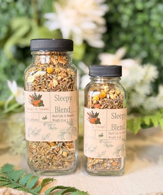 Herbal tea called Sleepy Blend by Sage & Stone Apothecary, featuring a tea bag and a cup of brewed herbal tea on a cozy setting.