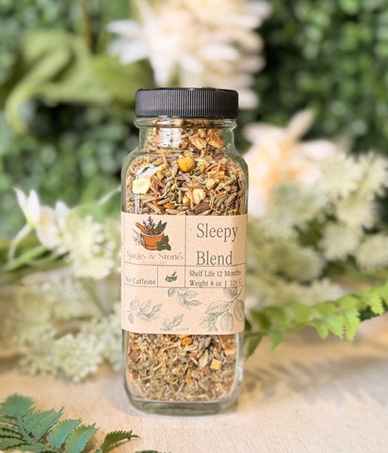 8 oz Sleepy Blend herbal tea by Sage & Stone Apothecary in a clear tea bag with dried herbs and flowers.