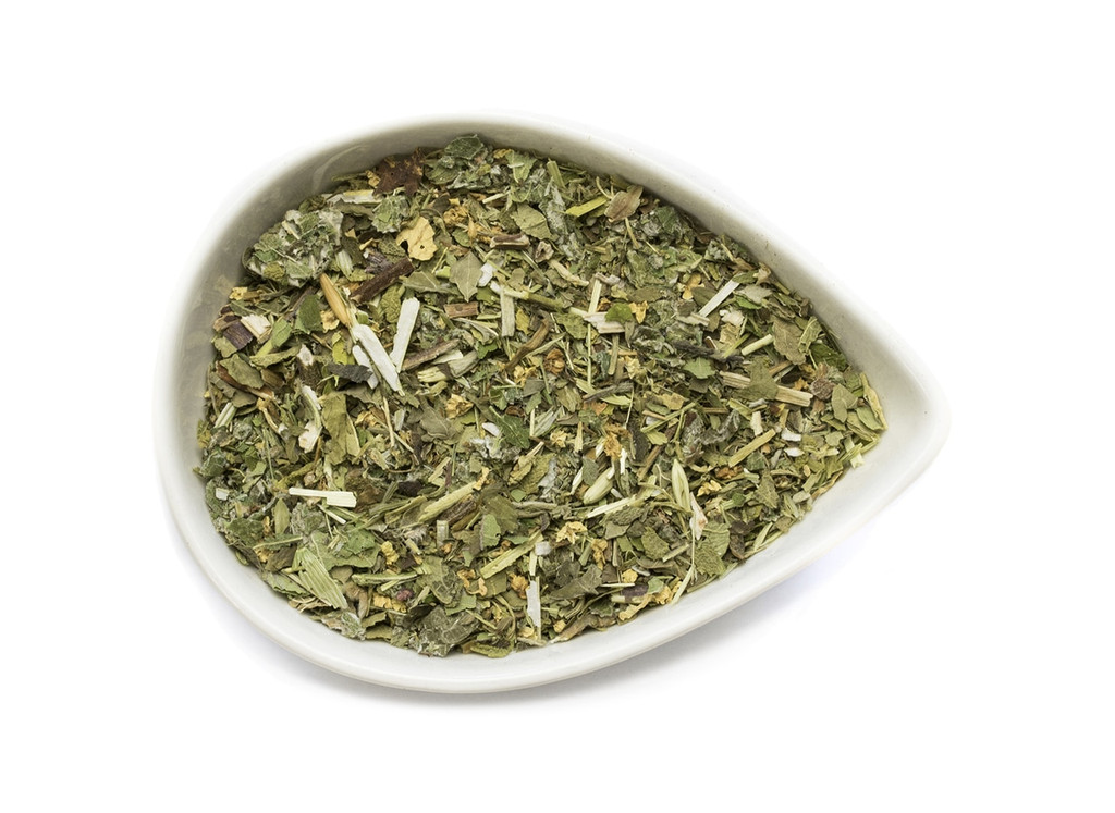 A cup of sage and stone apothecary gratitude tea with herbal tea leaves and a peaceful setting, showcasing the tea's calming qualities.